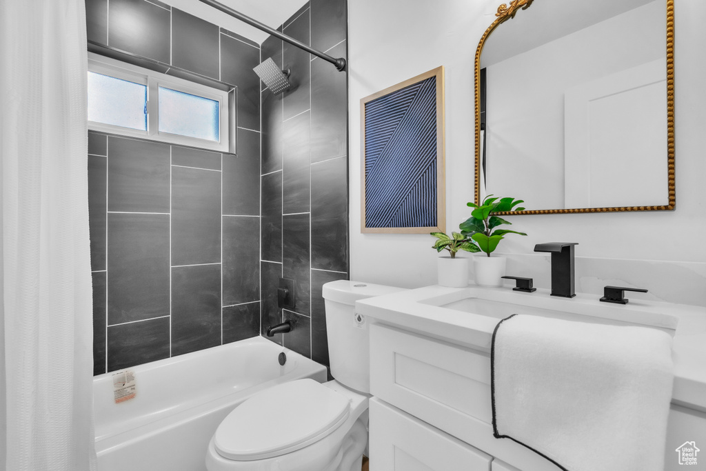 Bathroom featuring shower / bath combo with shower curtain, vanity, and toilet
