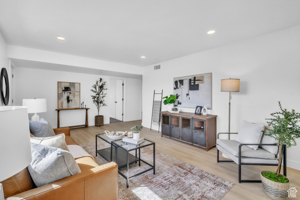 Living area featuring light wood-type flooring, recessed lighting, and visible vents