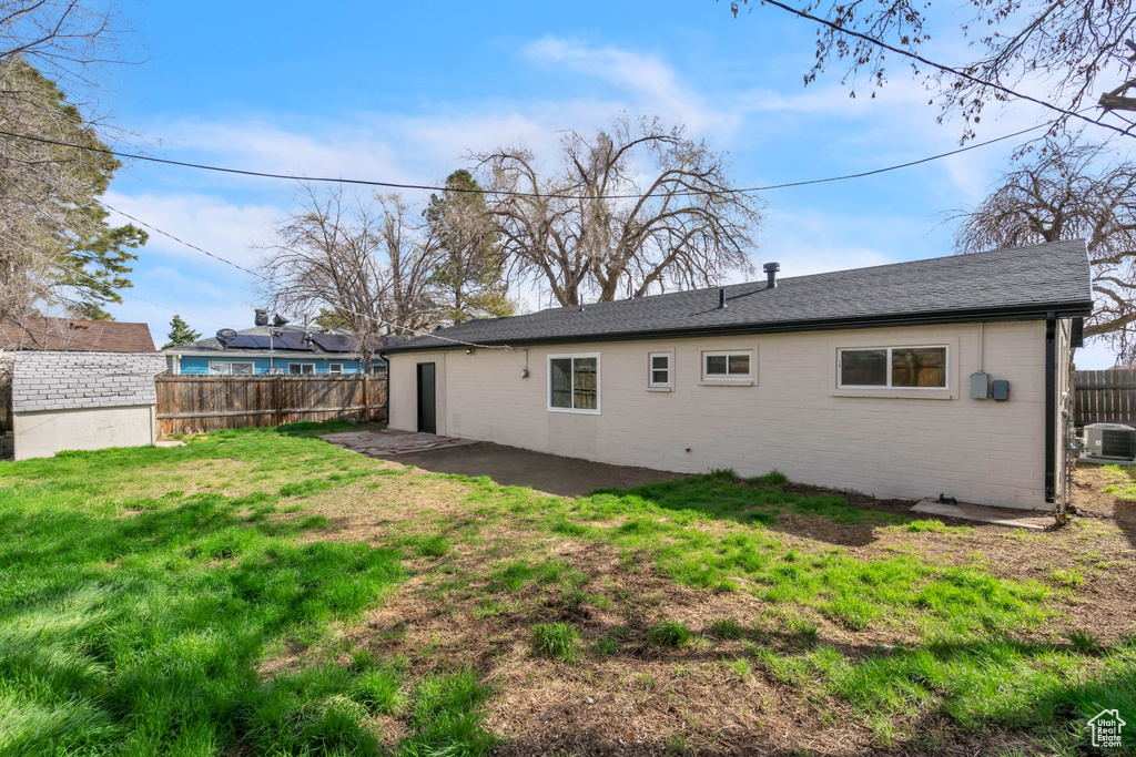 Back of property with a lawn, cooling unit, a patio, and fence private yard