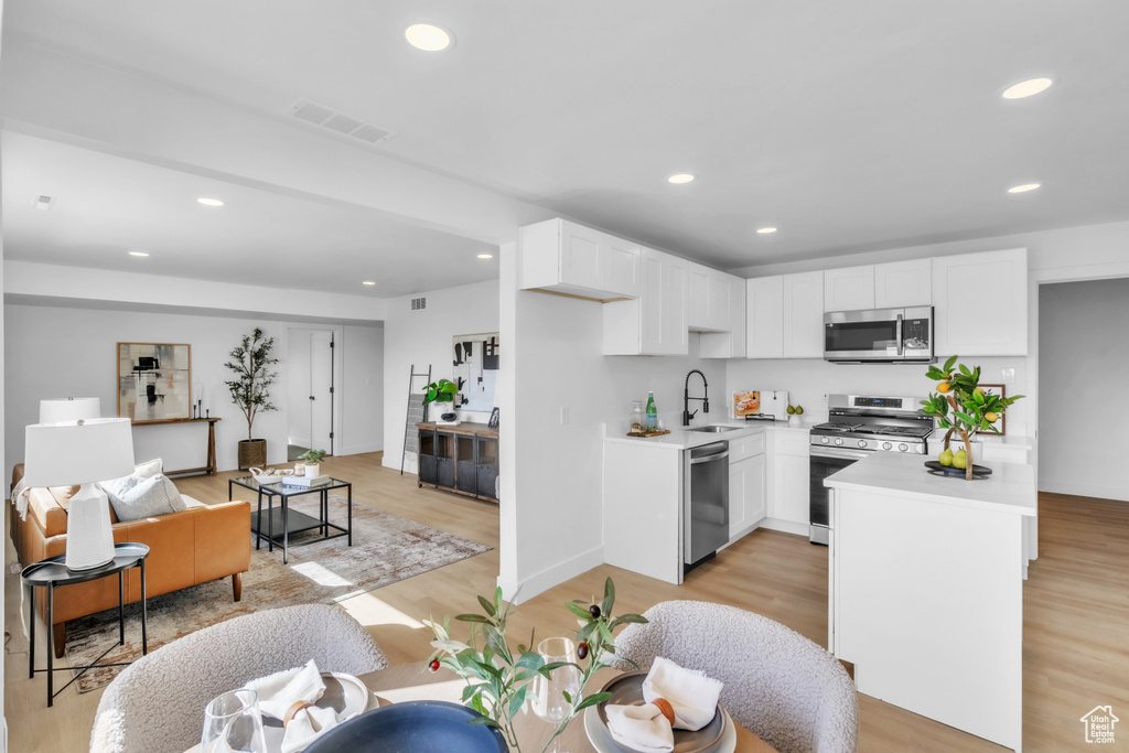 Kitchen featuring light countertops, light wood-style flooring, visible vents, stainless steel appliances, and recessed lighting