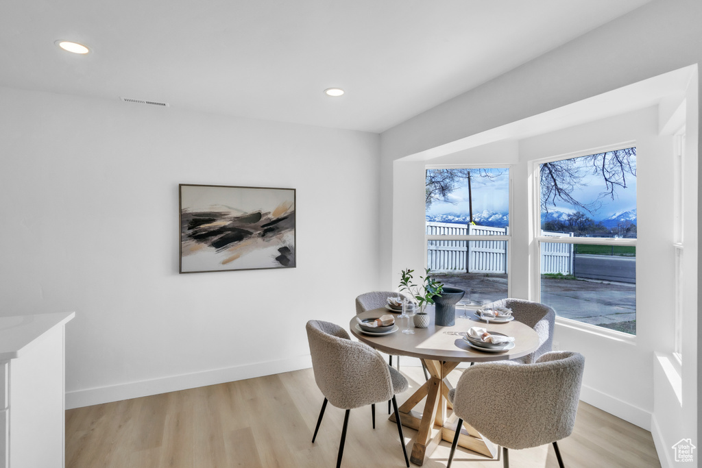 Dining space with light wood finished floors, baseboards, visible vents, and recessed lighting