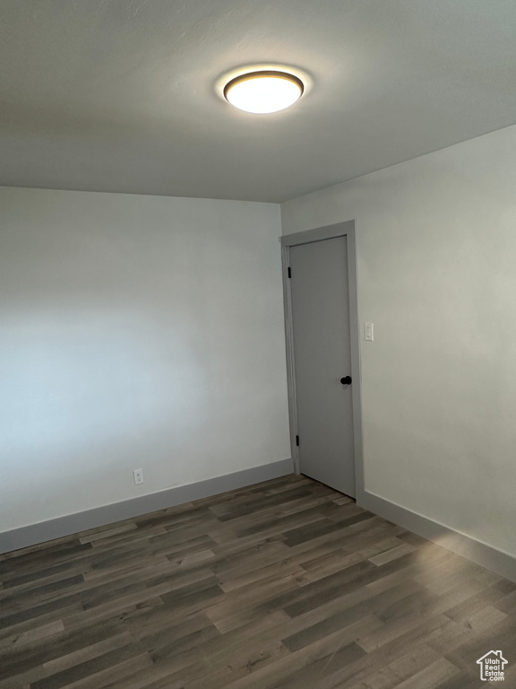 Spare room with baseboards and wood finished floors