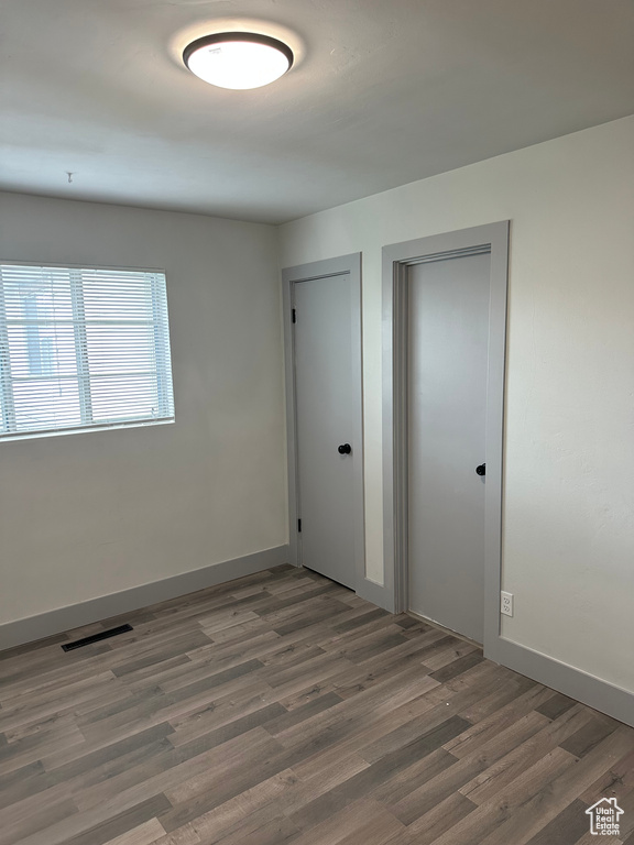 Unfurnished room with baseboards, visible vents, and wood finished floors