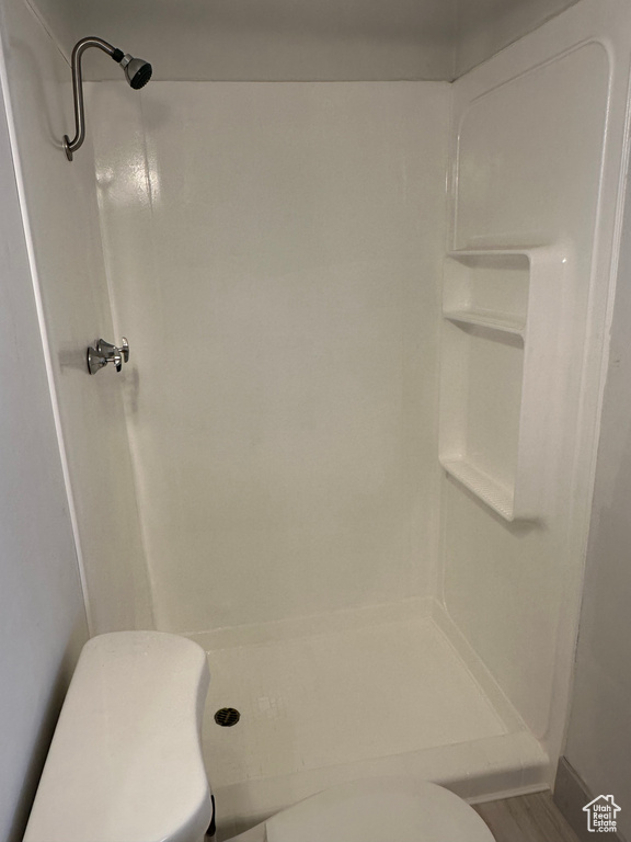 Full bath featuring toilet and a stall shower