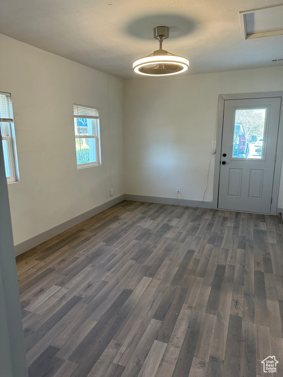 Unfurnished dining area featuring baseboards and wood finished floors