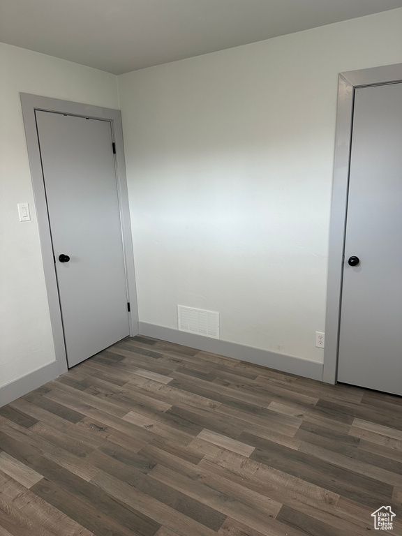 Unfurnished room with baseboards, visible vents, and wood finished floors