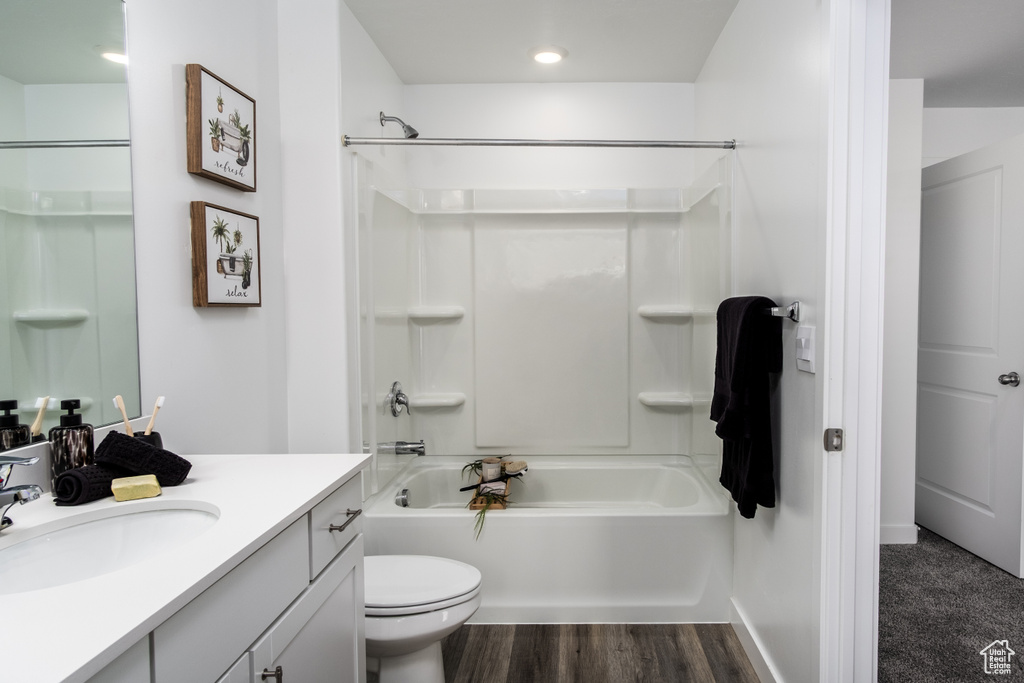 Full bath with toilet, shower / tub combination, vanity, and wood finished floors