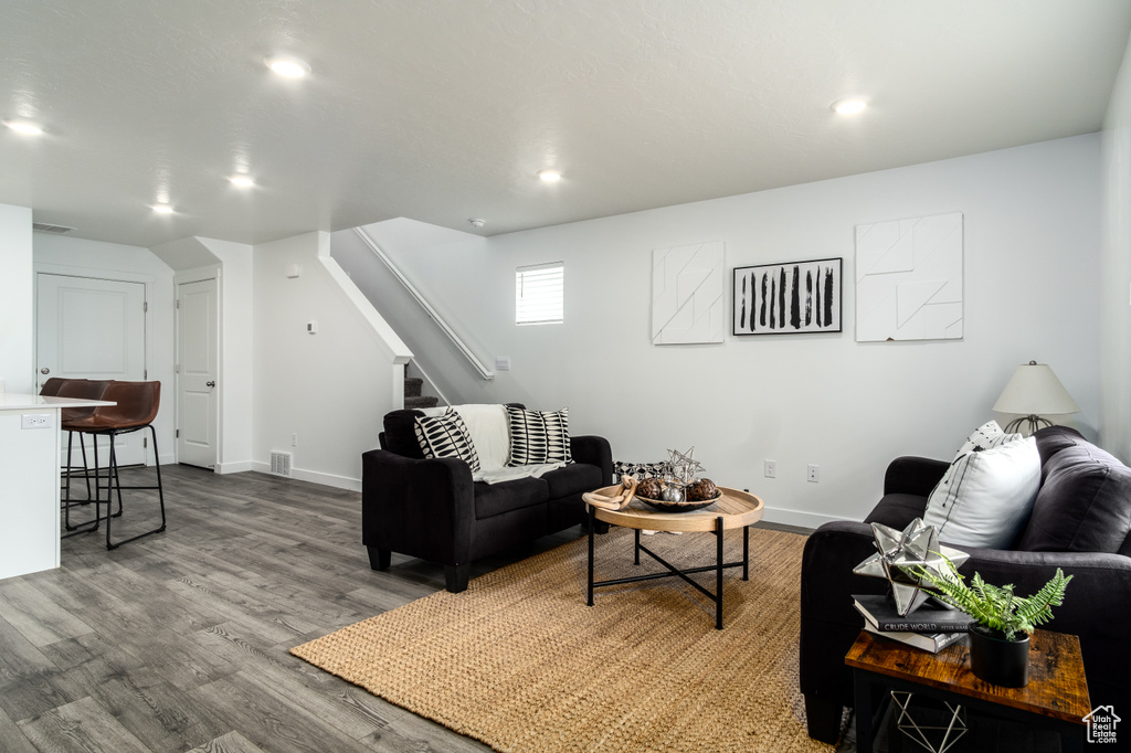 Living area with baseboards, recessed lighting, wood finished floors, and stairway