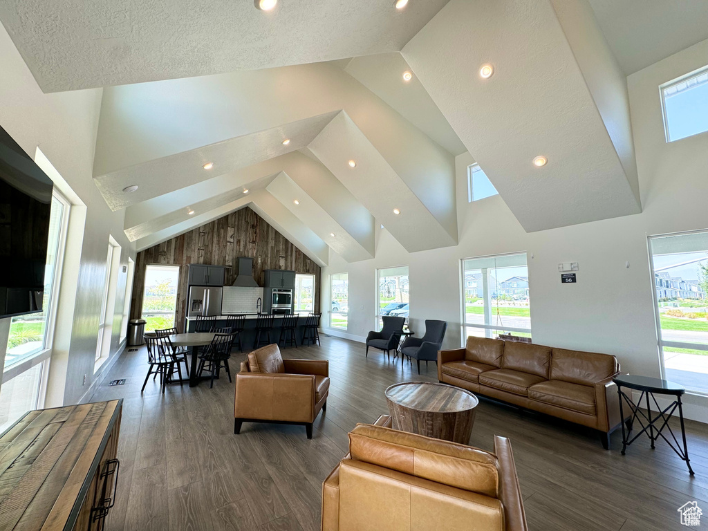 Living room featuring dark wood-type flooring, high vaulted ceiling, and baseboards