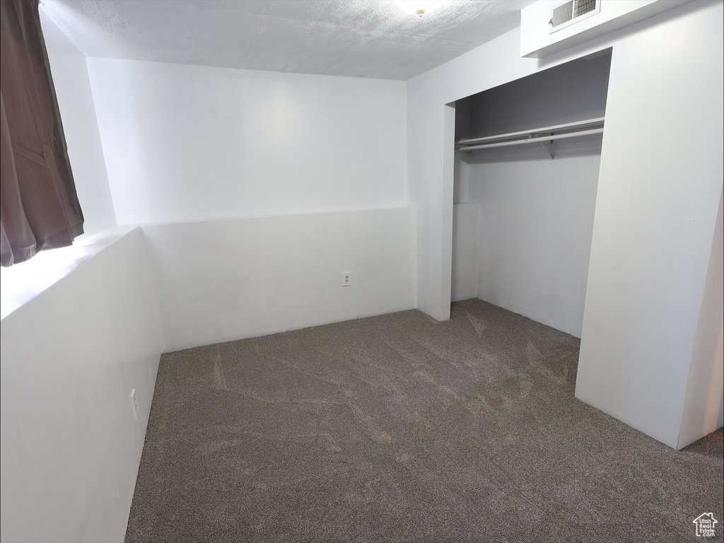 Unfurnished bedroom with visible vents, carpet flooring, and a closet