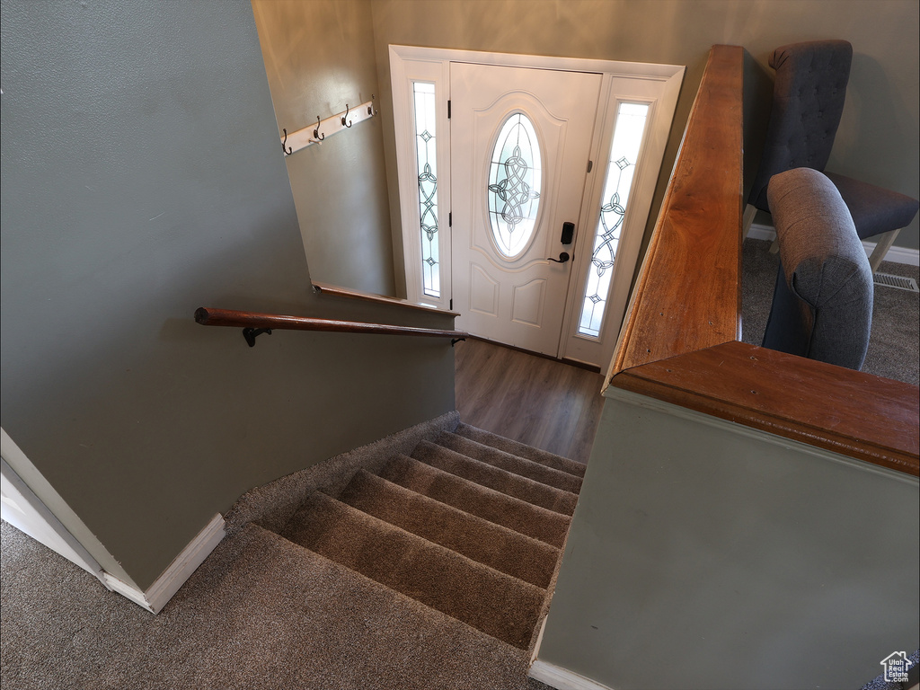 Entryway with baseboards, stairs, and wood finished floors