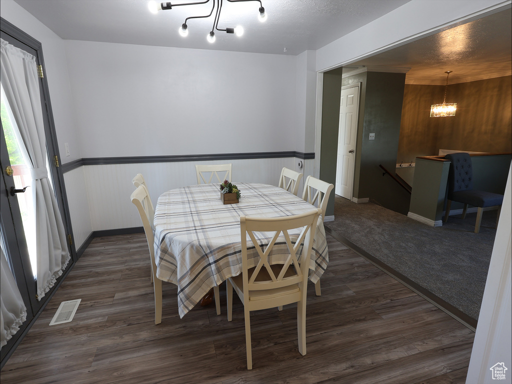 Dining space with visible vents, dark wood-style flooring, baseboards, and a chandelier