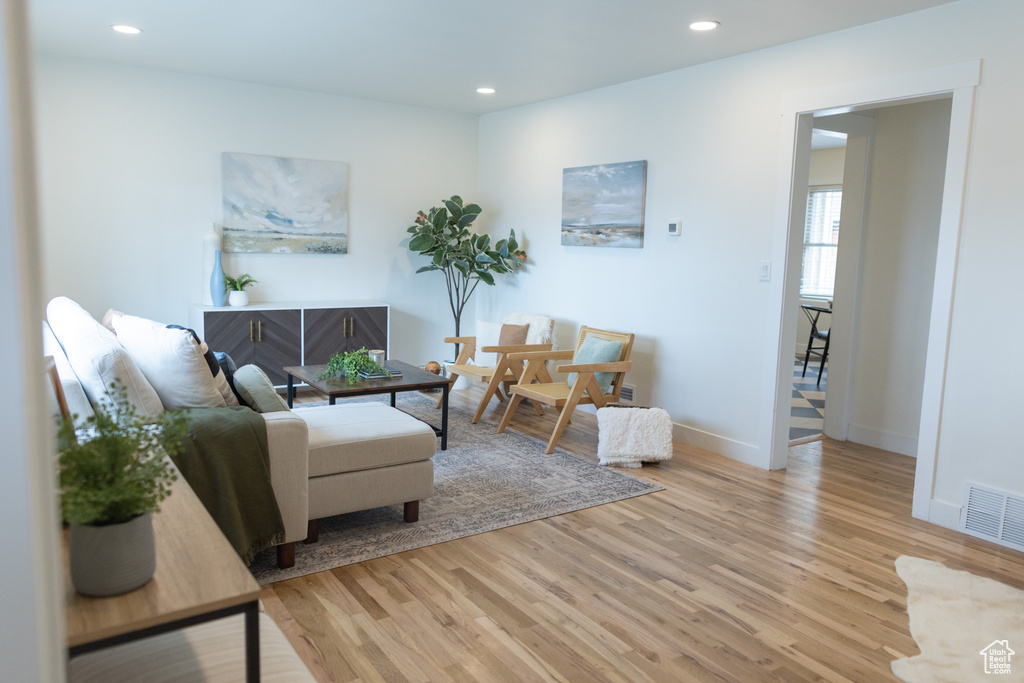 Living room with baseboards, visible vents, light wood-style floors, and recessed lighting