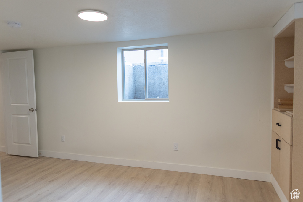 Spare room with baseboards and light wood-style floors