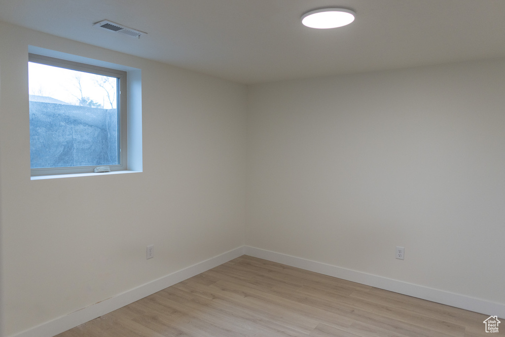 Unfurnished room with baseboards, visible vents, and light wood-type flooring