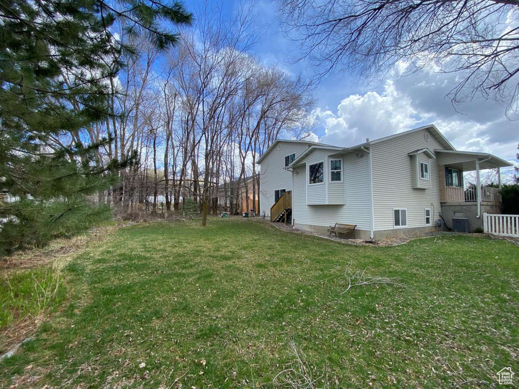 View of property exterior with central AC unit and a yard