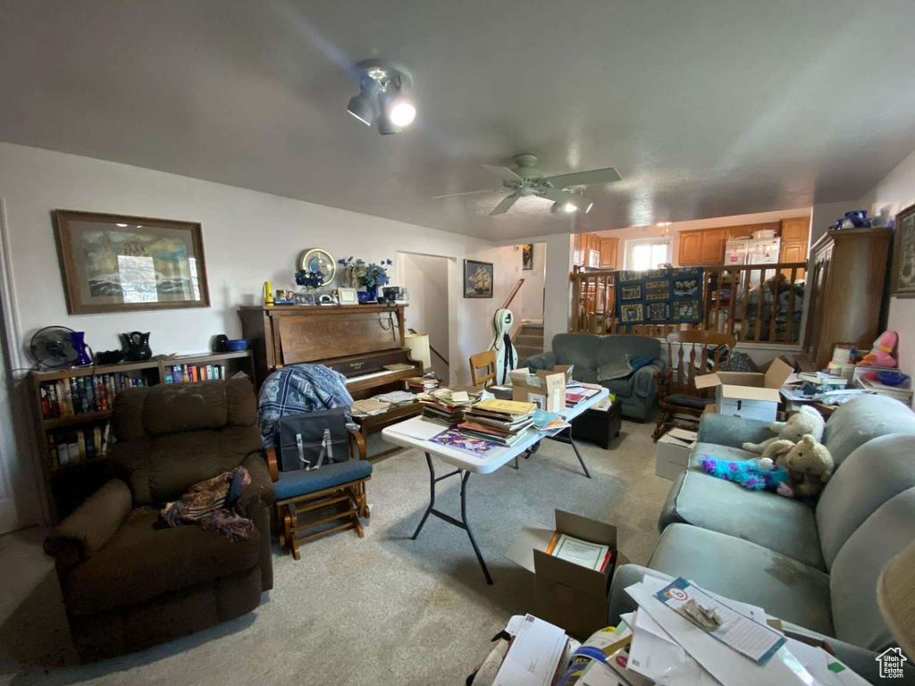 Living area featuring ceiling fan and carpet flooring