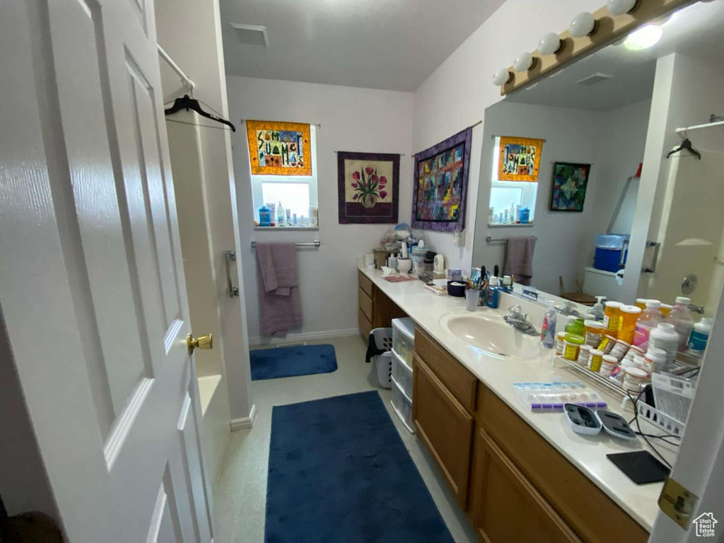 Bathroom featuring baseboards, visible vents, and vanity
