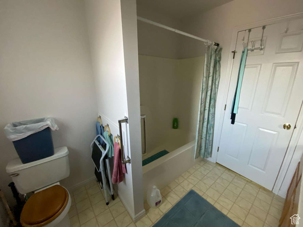 Full bath featuring toilet and shower / bath combo