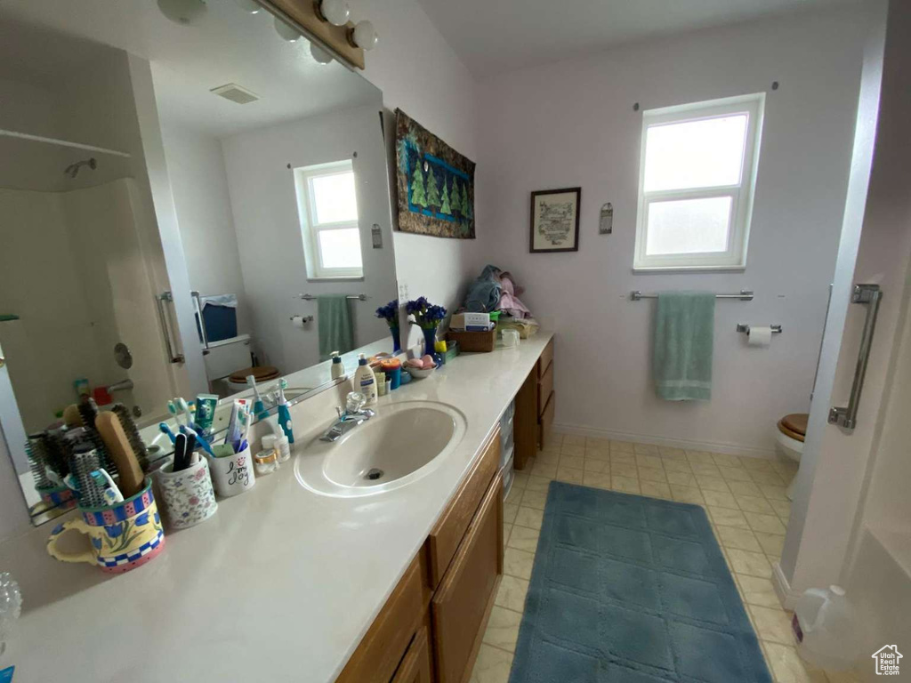 Full bathroom featuring a shower, toilet, vanity, and visible vents