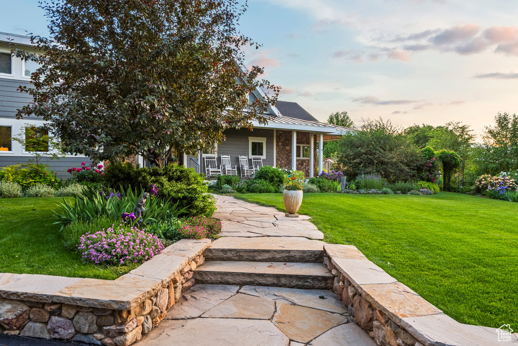 View of front of house with a porch, a yard, a metal roof, and a standing seam roof