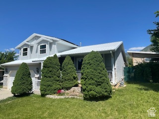 View of front of house featuring a front yard and an attached garage