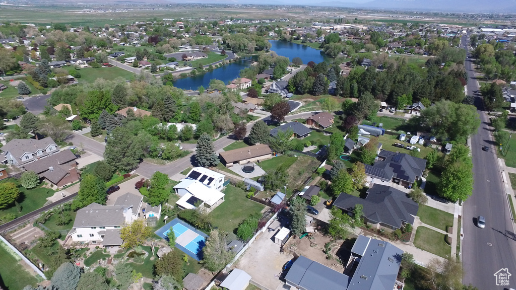 Aerial view of property and surrounding area featuring a nearby body of water and nearby suburban area