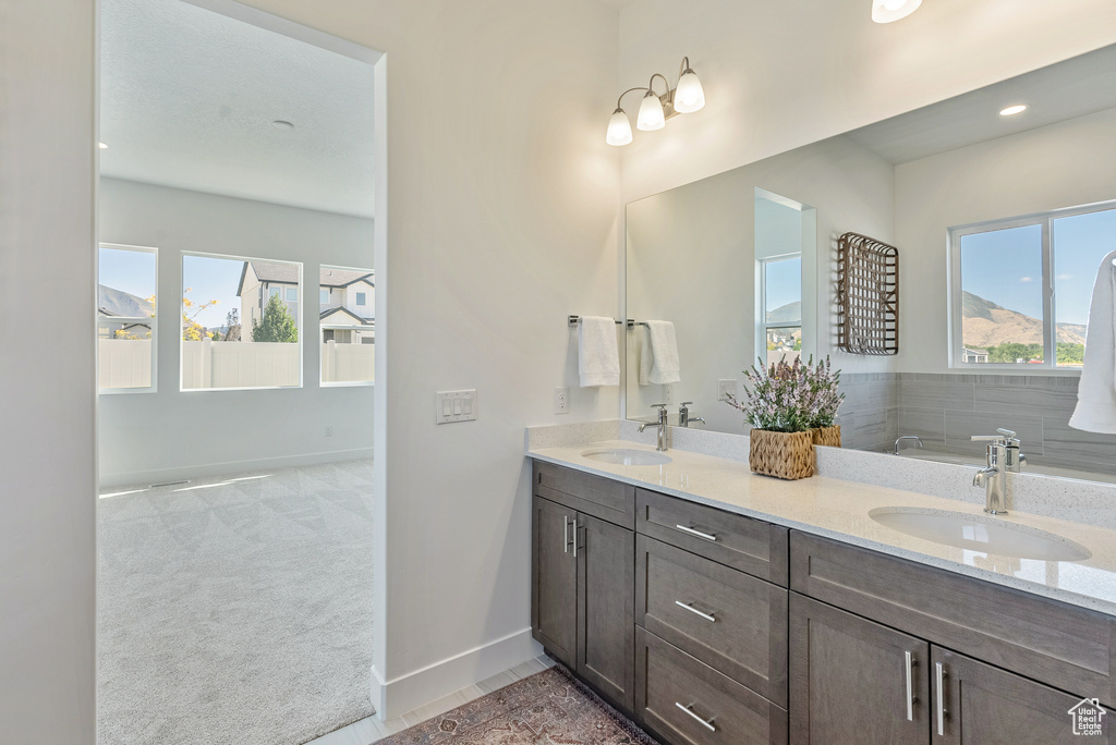 Bathroom with double vanity, a sink, and plenty of natural light