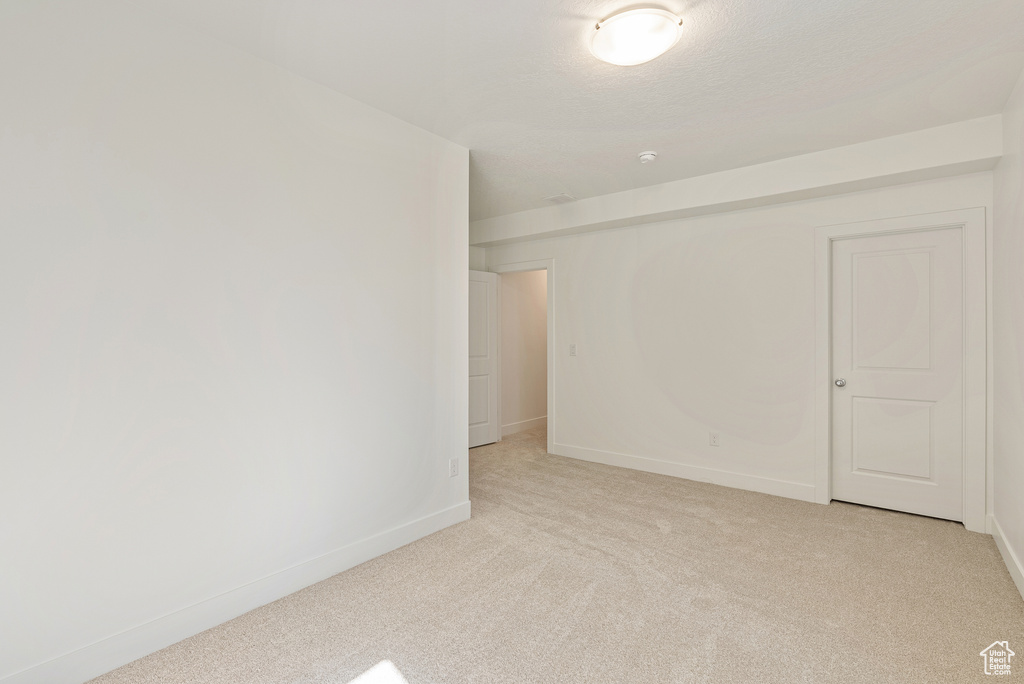 Spare room featuring baseboards and light colored carpet