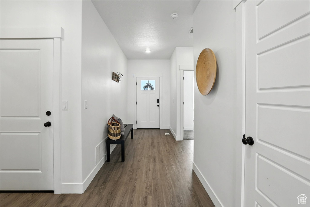 Entrance foyer featuring baseboards and dark wood-type flooring