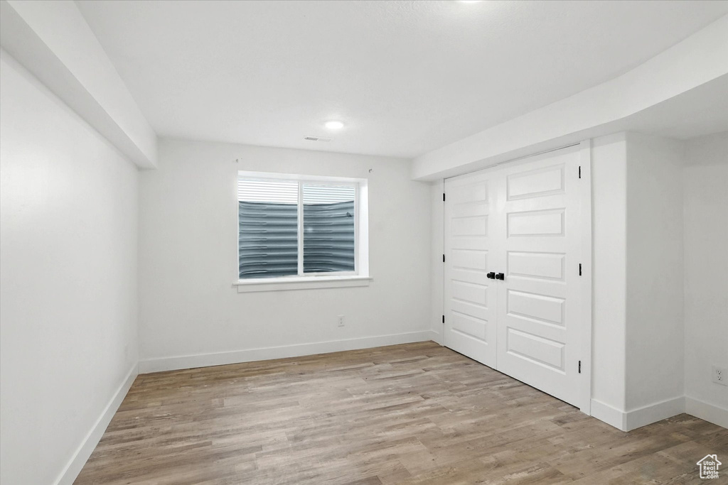 Unfurnished bedroom with light wood-style floors, recessed lighting, and a closet