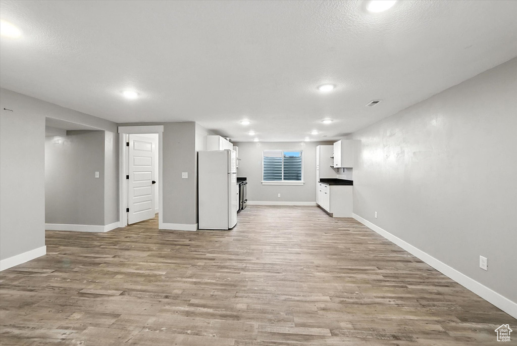 Unfurnished living room featuring light wood-type flooring, recessed lighting, and a textured ceiling