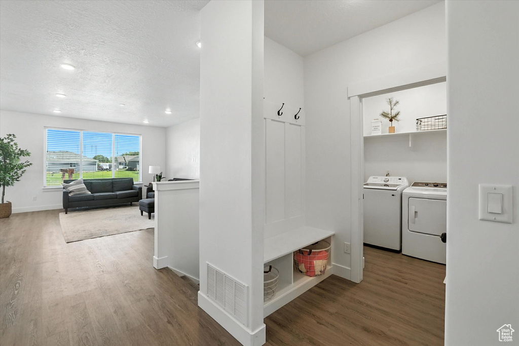 Mudroom with separate washer and dryer, wood finished floors, a textured ceiling, and recessed lighting