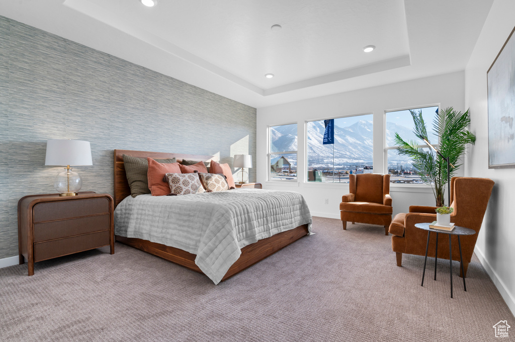Carpeted bedroom featuring baseboards, wallpapered walls, recessed lighting, a raised ceiling, and an accent wall