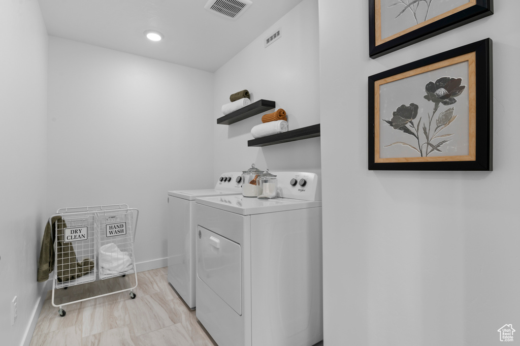 Laundry room with washer and clothes dryer, visible vents, laundry area, and baseboards
