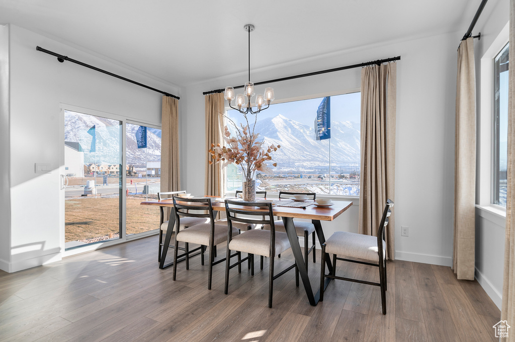 Dining area with baseboards, wood finished floors, and a notable chandelier