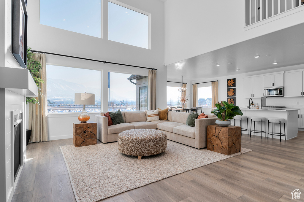 Living room with baseboards, a fireplace, light wood-style floors, and recessed lighting