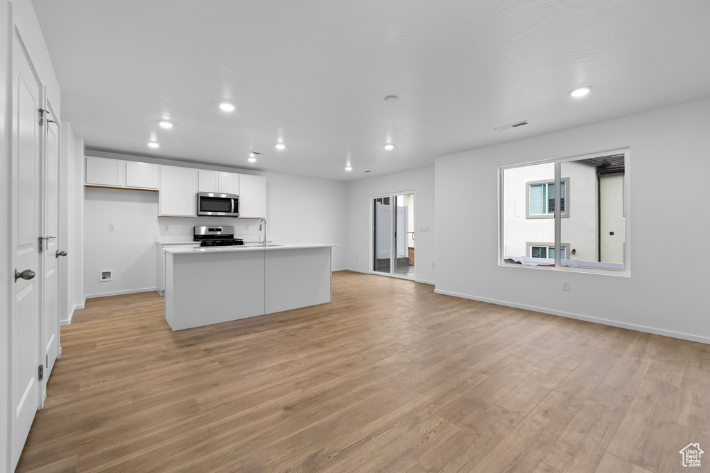 Kitchen featuring white cabinetry, recessed lighting, light wood-type flooring, and appliances with stainless steel finishes