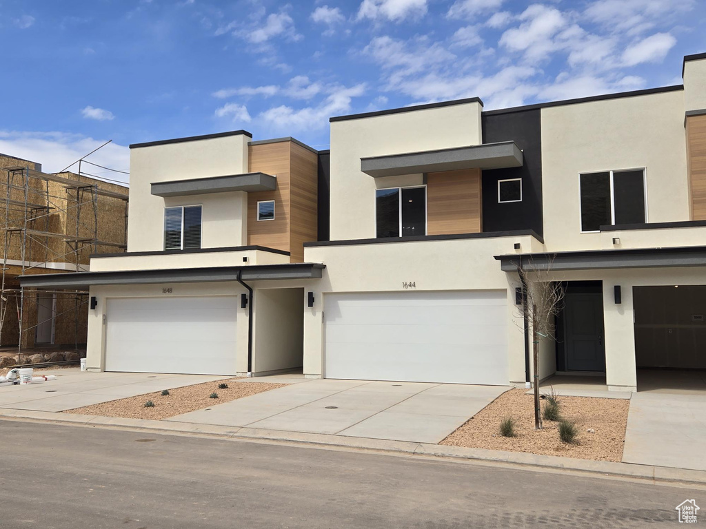 Contemporary house featuring stucco siding, driveway, and a garage