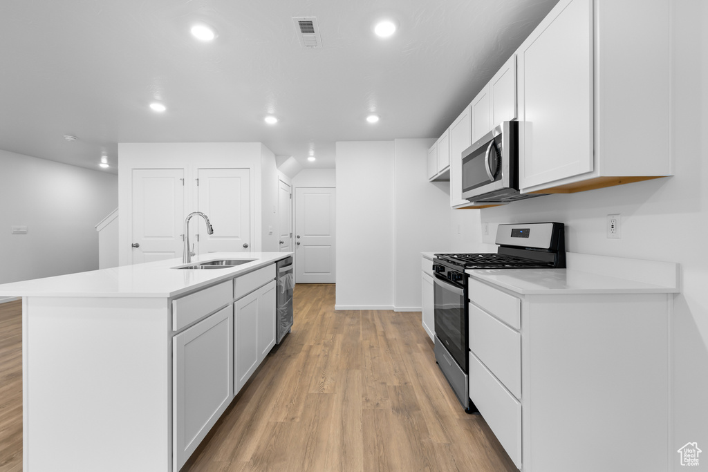 Kitchen featuring recessed lighting, stainless steel appliances, a sink, visible vents, and light wood-style flooring