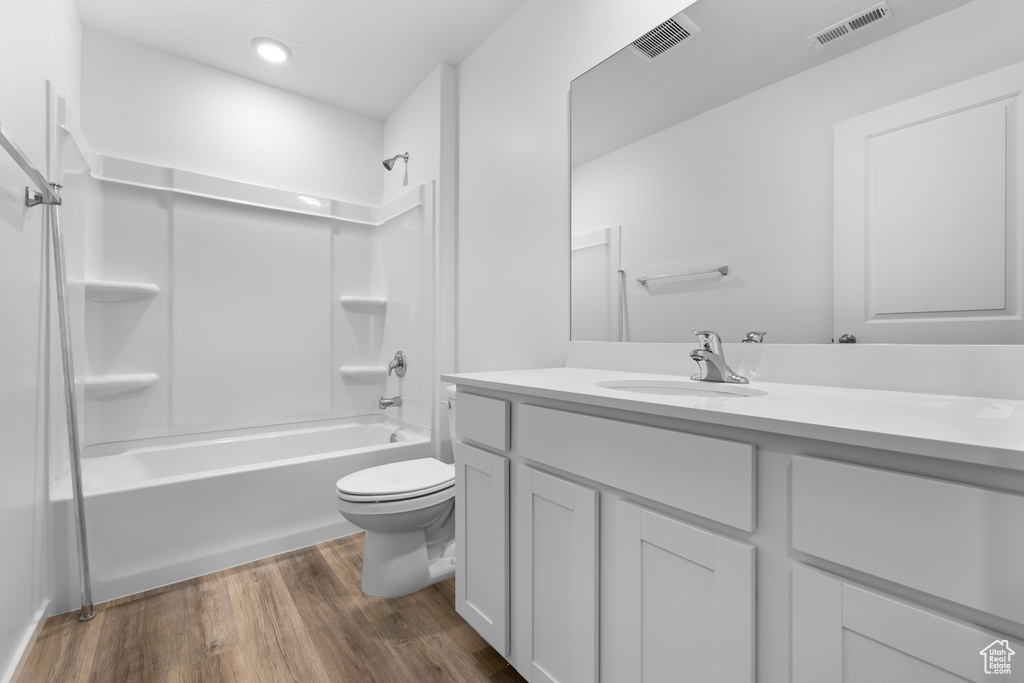 Bathroom featuring visible vents, toilet, vanity, and wood finished floors