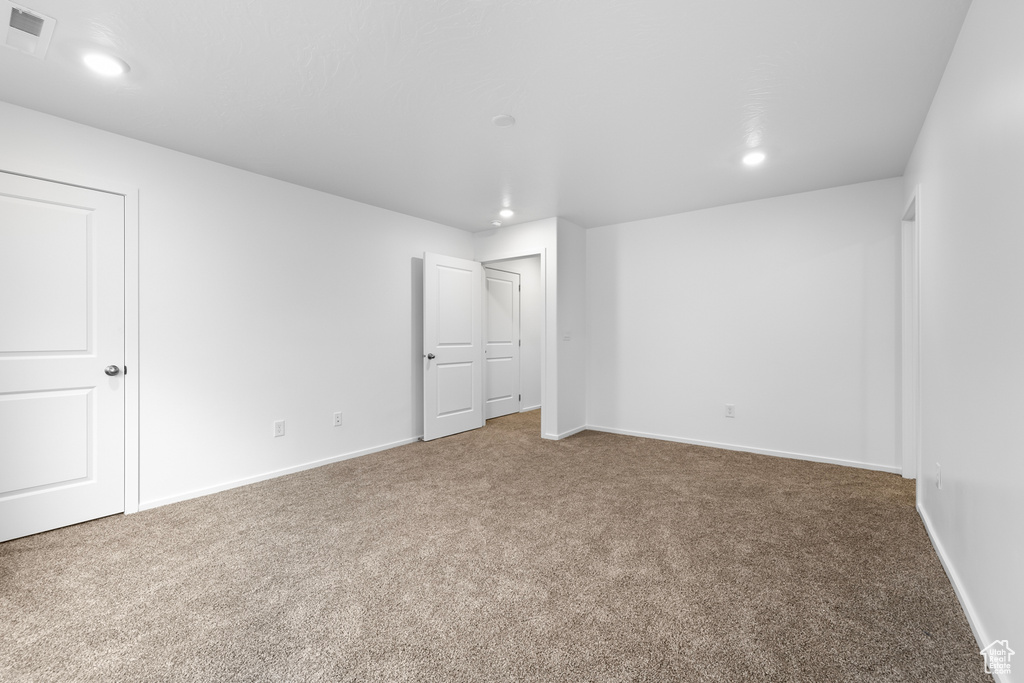 Interior space with baseboards, visible vents, recessed lighting, and carpet