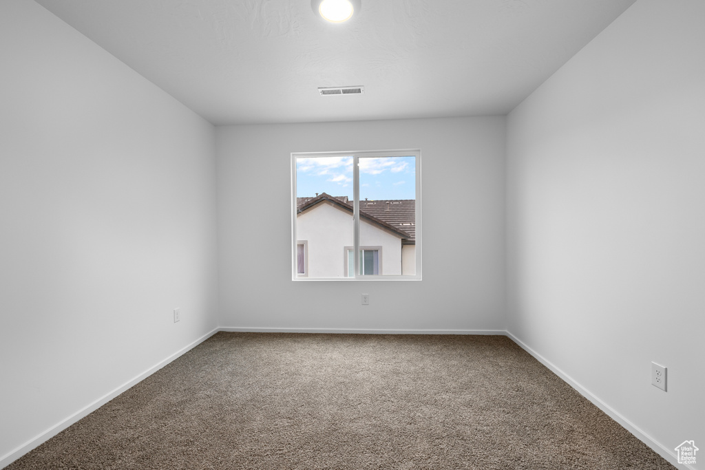 Carpeted spare room with baseboards and visible vents