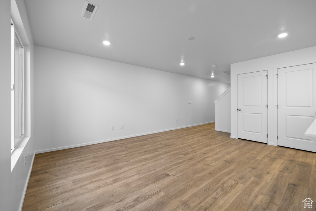 Basement featuring baseboards, visible vents, recessed lighting, and light wood-type flooring