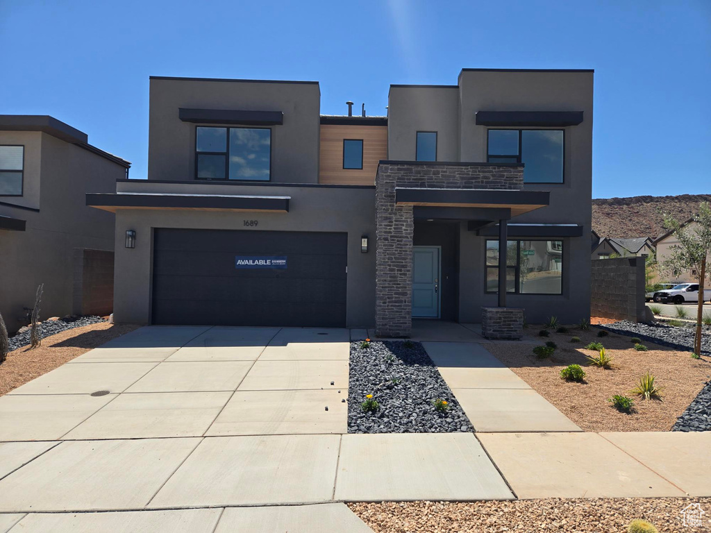 Contemporary house with stucco siding, concrete driveway, and an attached garage