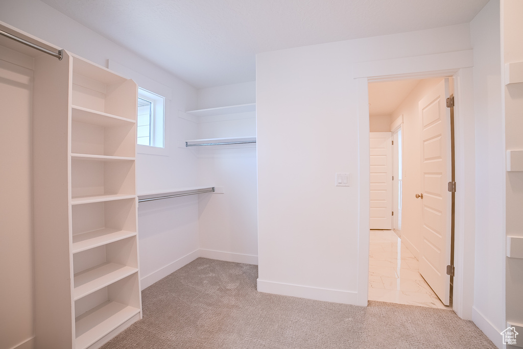 Walk in closet with light carpet