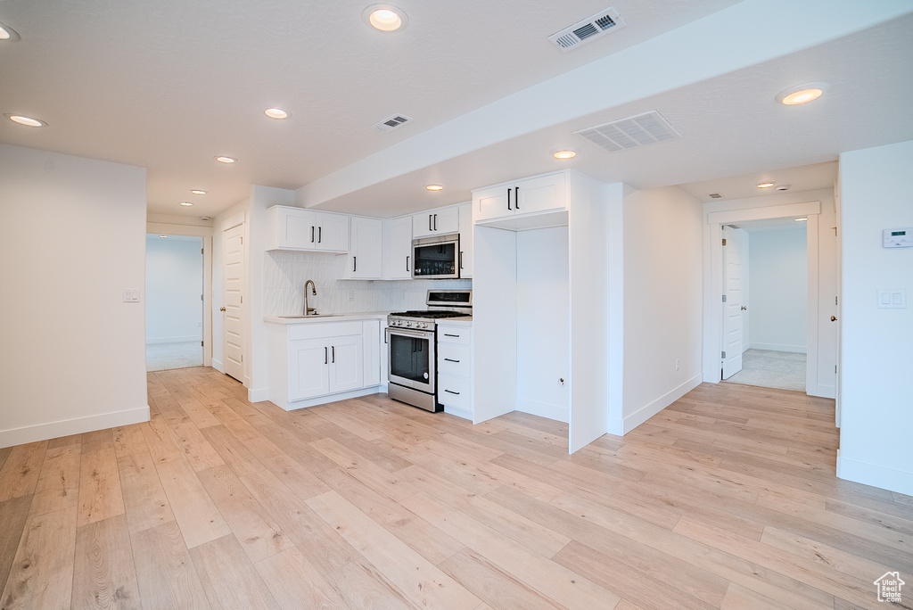 Kitchen with visible vents, a sink, light wood-style floors, and appliances with stainless steel finishes
