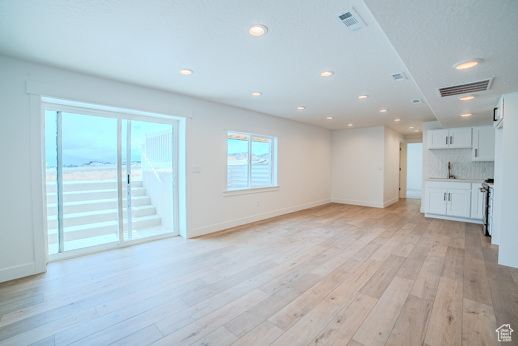 Unfurnished living room with recessed lighting, baseboards, and visible vents