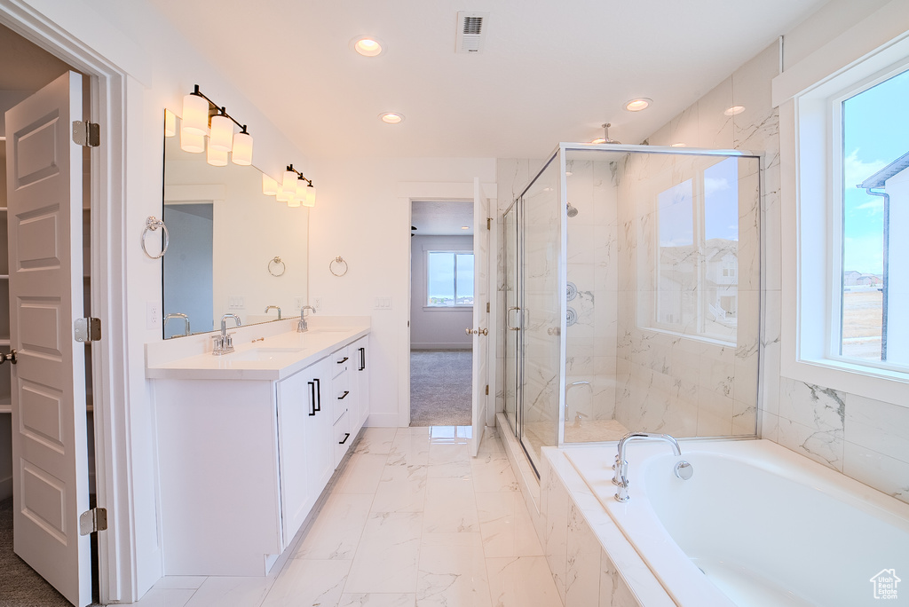 Bathroom featuring a garden tub, double vanity, marble finish floor, a sink, and a marble finish shower