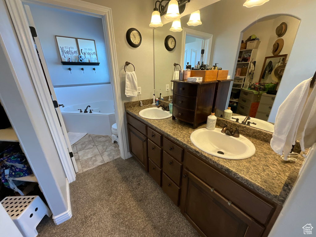 Full bath featuring double vanity, a sink, and a garden tub